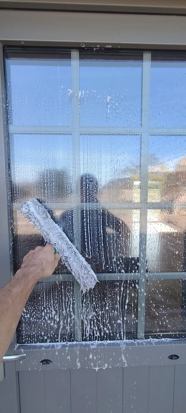 Passage du mouilleur sur une porte vitrée pendant le nettoyage CANOPA