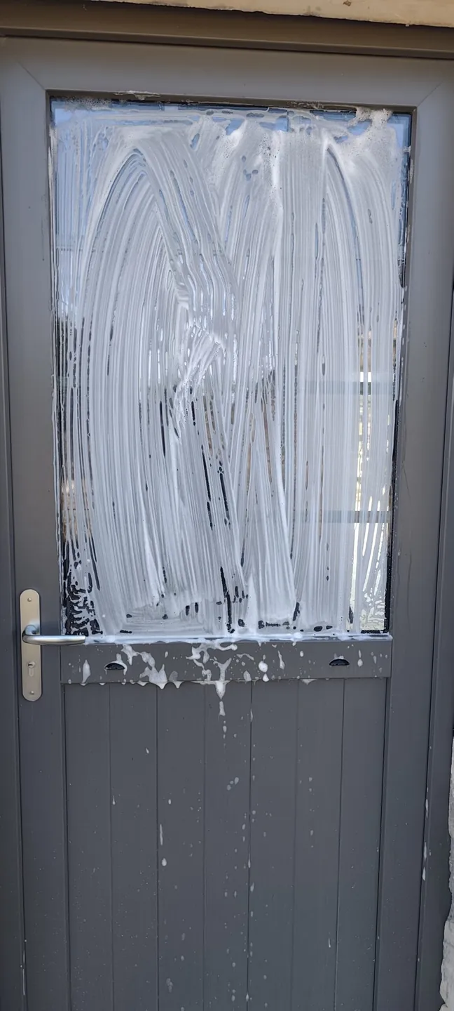 Porte vitrée recouverte de produit pendant le lavage par CANOPA